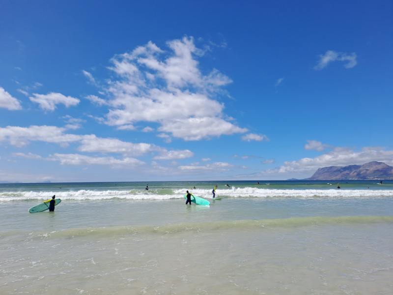 Surfers carrying their boards to the water at Muizenberg Beach